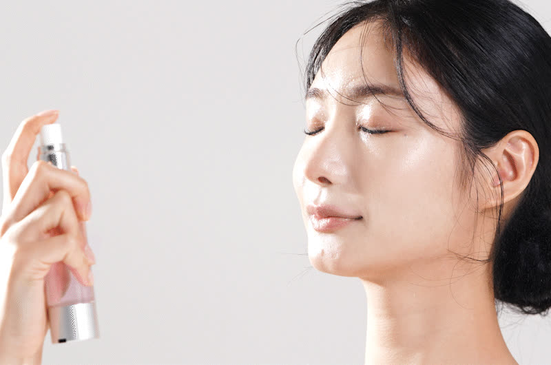 얼굴에 미스트를 뿌리는 모델